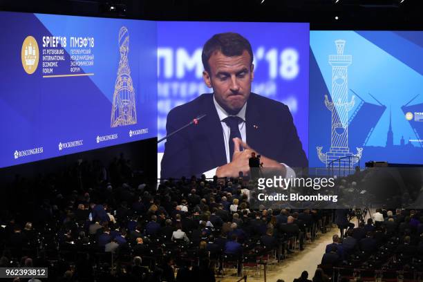 Emmanuel Macron, France's president, speaks on screen during a panel discussion during the plenary session at the St. Petersburg International...