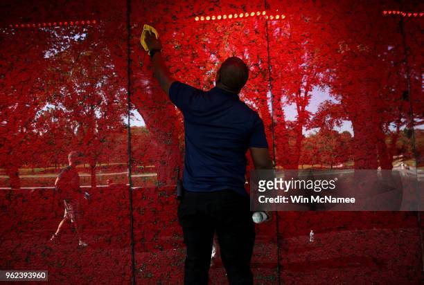 Romel Martin cleans glass panels while assisting with the installation of a temporary pop-up 'Poppy Memorial' on the national mall near the Lincoln...