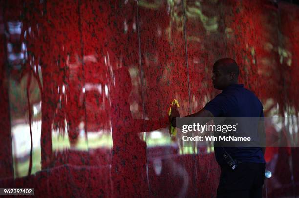 Romel Martin cleans glass panels while assisting with the installation of a temporary pop-up 'Poppy Memorial' on the national mall near the Lincoln...