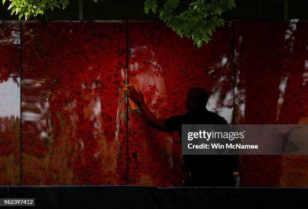 Romel Martin cleans glass panels while assisting with the installation of a temporary pop-up 'Poppy Memorial' on the national mall near the Lincoln...