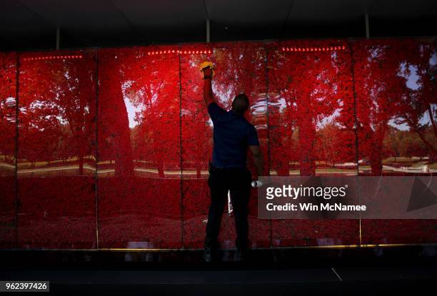 Romel Martin cleans glass panels while assisting with the installation of a temporary pop-up 'Poppy Memorial' on the national mall near the Lincoln...