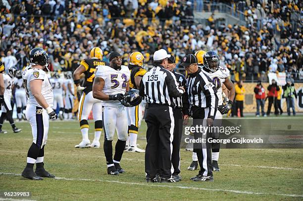 Linebackers Ray Lewis and Antwan Barnes of the Baltimore Ravens watch as referee Pete Morelli discusses an official's call with side judge Laird...
