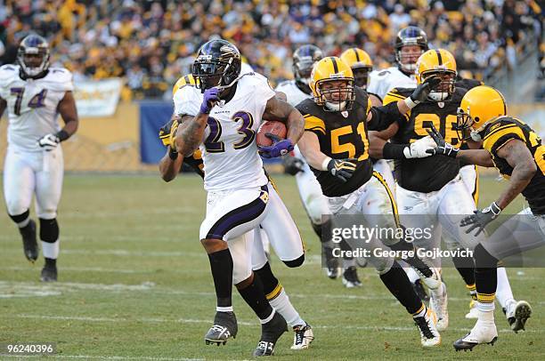 Running back Willis McGahee of the Baltimore Ravens is chased by linebacker James Farrior, defensive lineman Ziggy Hood and defensive back Ike Taylor...