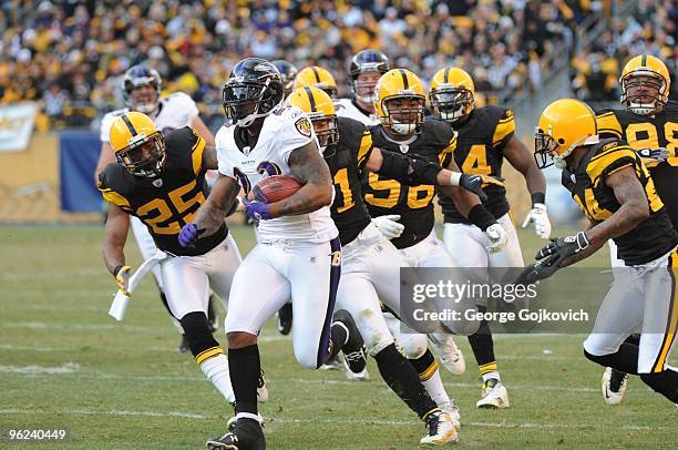 Running back Willis McGahee of the Baltimore Ravens is chased by defensive back Ryan Clark, linebacker James Farrior, defensive lineman Ziggy Hood...