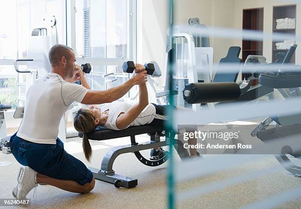 personal trainer helping woman work out - personlig tränare bildbanksfoton och bilder