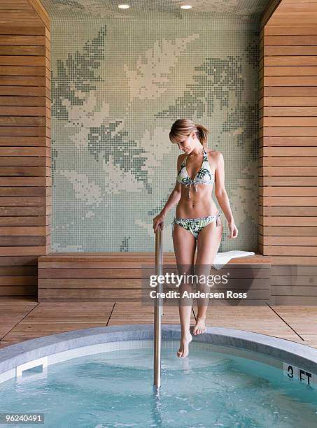 woman stepping into spa tub - wasser treten stock-fotos und bilder