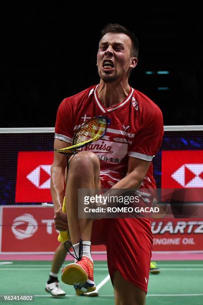 Anders Skaarup Rasmussen of Denmark breaks his racket after defeating Takuto Inoue and Yuki Kaneko of Japan during their men's doubles semifinals...