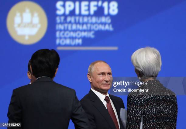 Vladimir Putin, Russia's president, center, shakes hands with Christine Lagarde, managing director of the International Monetary Fund , following the...