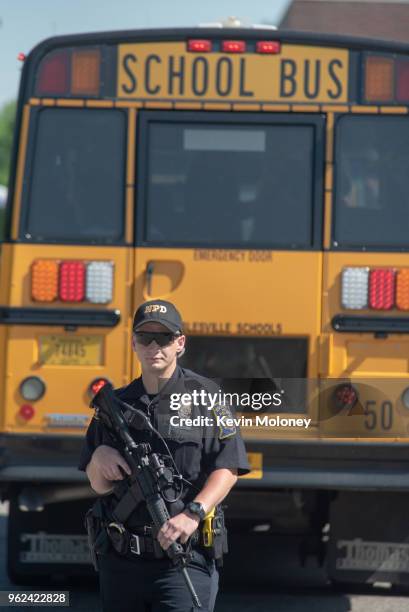 Police asses the scene outside Noblesville High School as evacuated middle school students wait on a bus after a shooting at Noblesville West Middle...