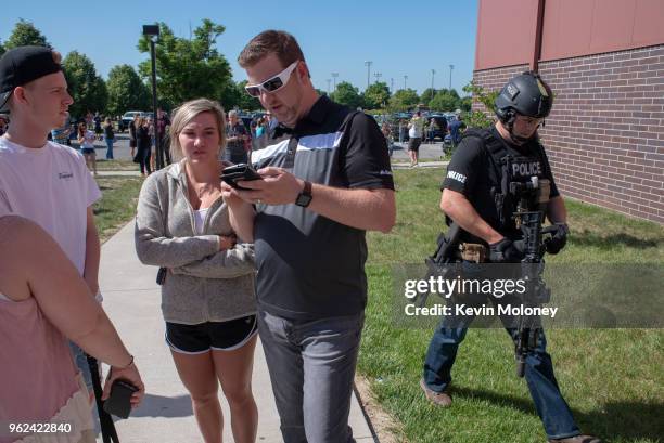 Parents wait while a SWAT officer passes outside Noblesville High School after a shooting at Noblesville West Middle School on May 25, 2018 in...