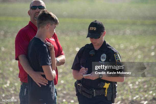 Police officer interviews a student and adult outside Noblesville West Middle School after a shooting at the school on May 25, 2018 in Noblesville,...