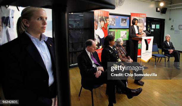 Secret Service agent watches as First lady Michelle Obama speaks about the government and community efforts to fight childhood obesity while visiting...