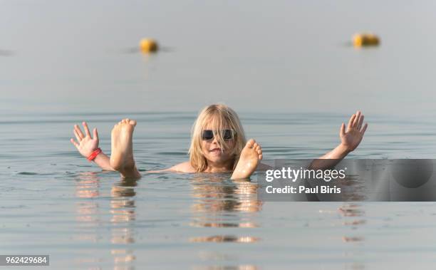 9y old boy floating in water of dead sea, jordan - boy lying dead stockfoto's en -beelden