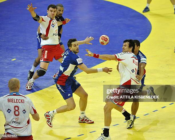 Polish Mariusz Jurkiewicz in action with his teammate Karol Bielecki and Daniel Zoltak as they clash with French Guillaume Gille and captain Daniel...