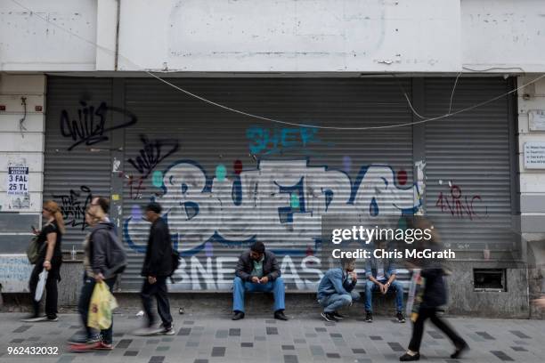Men sit in front of a closed shop on Istanbul's famous Istiklal shopping street on May 25, 2018 in Istanbul, Turkey. Fears are growing that Turkey's...