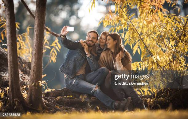 embraced family taking a selfie while enjoying in autumn day together. - boy taking picture in forest stock pictures, royalty-free photos & images