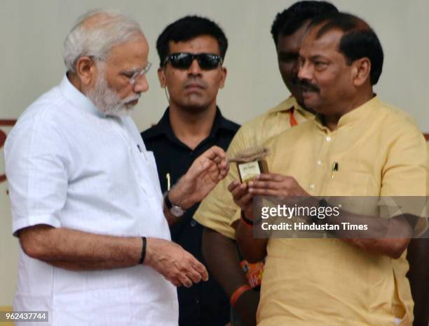 Prime Minister Narendra Modi recieves a gift from Jharkhand chief minister Raghubar Das at Baliapur on May 25, 2018 in Dhanbad, India. Modi laid...