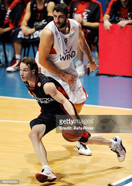 Marcelinho Huertas, #9 of Caja Laboral takes the ball past Ioannis Bourousis, #9 of Olympiacos Piraeus during the Euroleague Basketball 2009-2010...