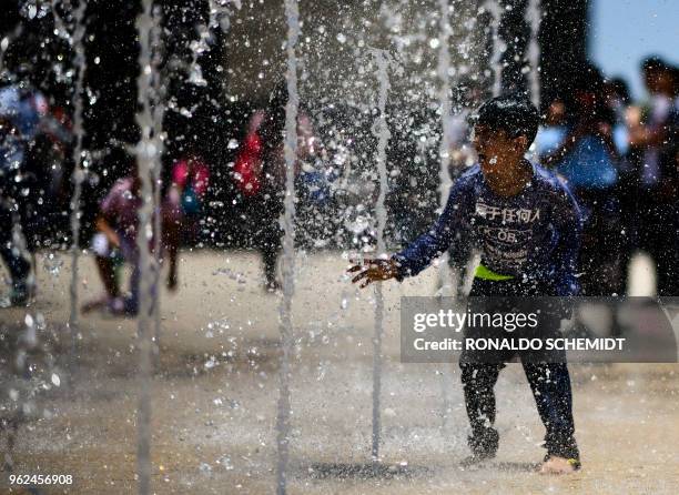 People play in a fountain at the Revolution Monument in Mexico City, on May 25, 2018.