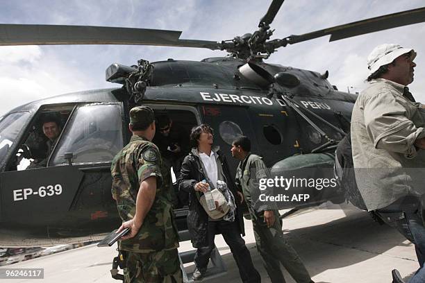 Foreign tourists alight from the Mi-8 military helicopter aboard which they were evacuated from the village of Aguas Calientes, near the Machu Picchu...