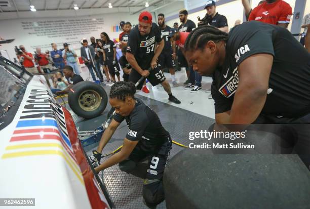 Tori Spann and Andre Hodge change a tire during the NASCAR Drive for Diversity Combine at the NASCAR Research and Development Center on May 25, 2018...