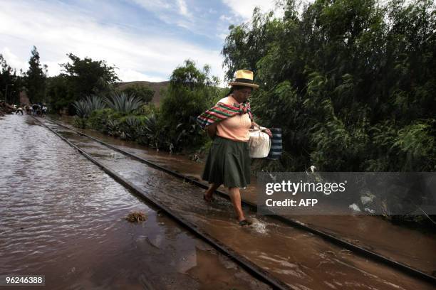 An Andean woman walks along the railway tracks flooded by the Vilcanota river in the village of Urubamba, near the Machu Picchu archaeological site...