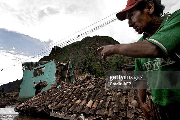 Man points to a house that was destroyed by the flooding of the Vilcanota river in the village of Urubamba, near Machu Picchu archaeological site, in...