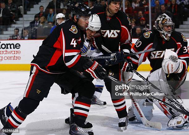 Chris Phillips, Filip Kuba and goalie Brian Elliott of the Ottawa Senators skate for the puck against Keith Tkachuk of the St. Louis Blues in a game...