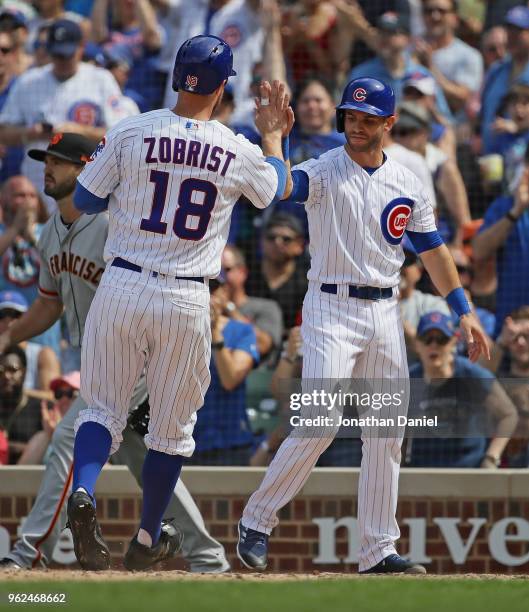 Tommy La Stella of the Chicago Cubs greets Ben Zobrist after they score in the 7th inning against the San Francisco Giants at Wrigley Field on May...