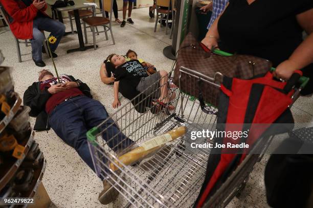 Protesters participate in a "die'-in" protest in a Publix supermarket on May 25, 2018 in Coral Springs, Florida. The activists many of whom are...