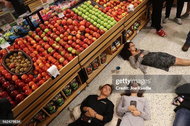 Protesters participate in a "die'-in" protest in a Publix supermarket on May 25, 2018 in Coral Springs, Florida. The activists many of whom are...