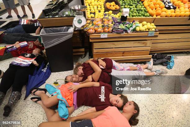 Protesters participate in a "die'-in" protest in a Publix supermarket on May 25, 2018 in Coral Springs, Florida. The activists many of whom are...