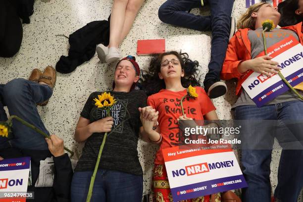 Protesters participate in a "die'-in" protest in a Publix supermarket on May 25, 2018 in Coral Springs, Florida. The activists many of whom are...