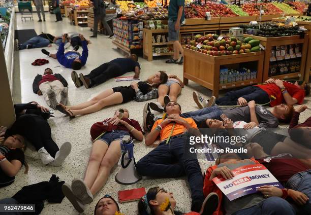 Protesters participate in a "die'-in" protest in a Publix supermarket on May 25, 2018 in Coral Springs, Florida. The activists many of whom are...