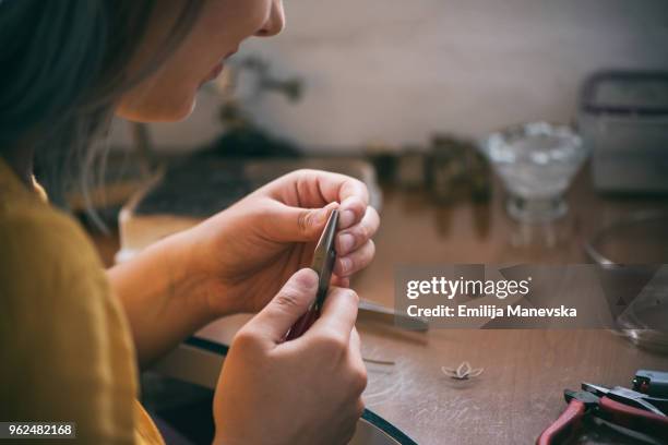 female jeweler making silver jewelry in workshop - making jewelry stockfoto's en -beelden