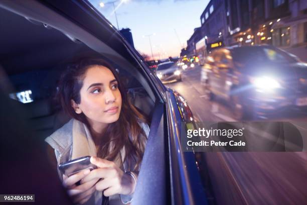 woman on phone in back of car, looking out of window - taxi stock pictures, royalty-free photos & images