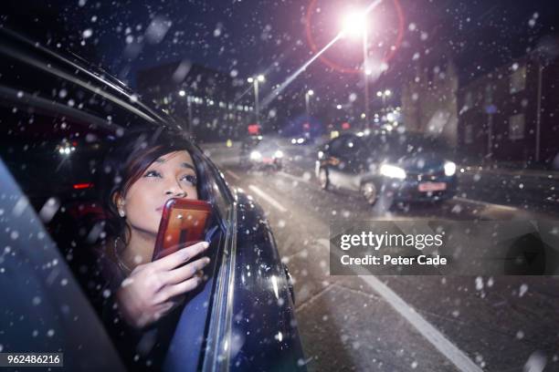 woman taking photo out of car window in snow - devon winer stock-fotos und bilder