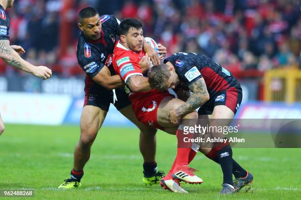 Justin Carney of Hull KR is tackled by Sam Powell and Willie Isa of Wigan Warriors during the Betfred Super League at KCOM Craven Park on May 25,...
