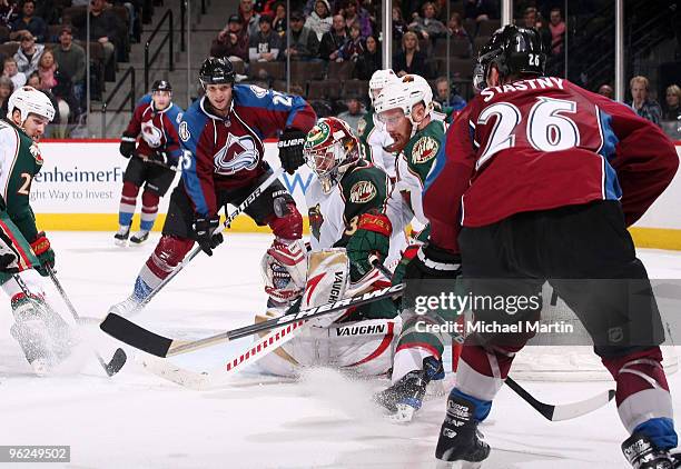 Goaltender Josh Harding of the Minnesota Wild makes a save in heavy traffic against Paul Stastny and Chris Stewart of the Colorado Avalanche at the...