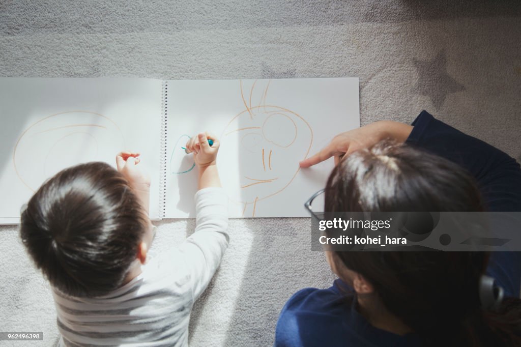 Mother and son drawing a picture at home