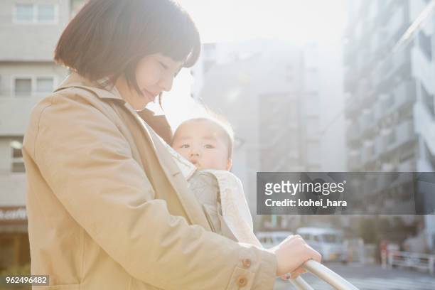 通りを歩いて母と赤ちゃんの女の子 - ベビーカー ストックフォトと画像