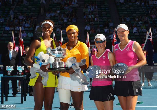 Venus Williams and Serena Williams of the USA and Cara Black of Zimbabwe and Liezel Huber of the USA pose with their trophies after their Women's...