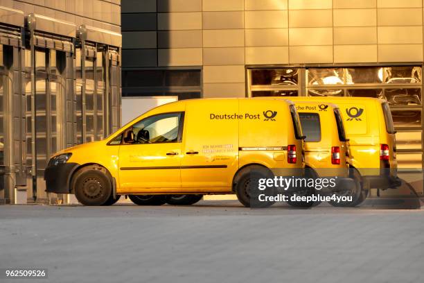 eine reihe von geparkten fahrzeugen der deutschen post - deutsche-post-ag stock-fotos und bilder