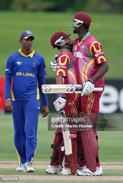 Yannic Cariah of the West Indies is hugged by team mate Jason Holder during the ICC U19 Cricket World Cup Super League quarter final between West...