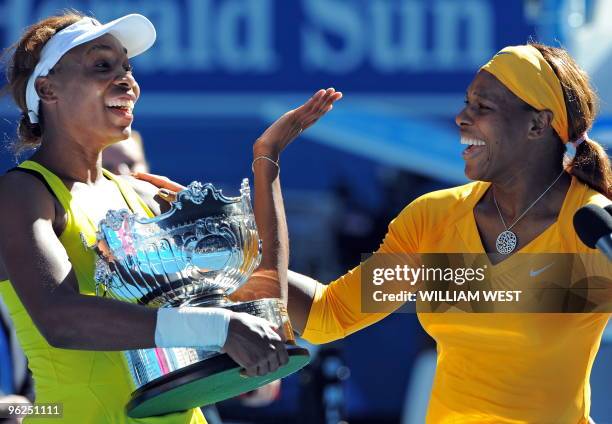 Serena Williams of the US and sister and partner Venus Williams of the US share a laugh as they joke around during the awards ceremony after beating...