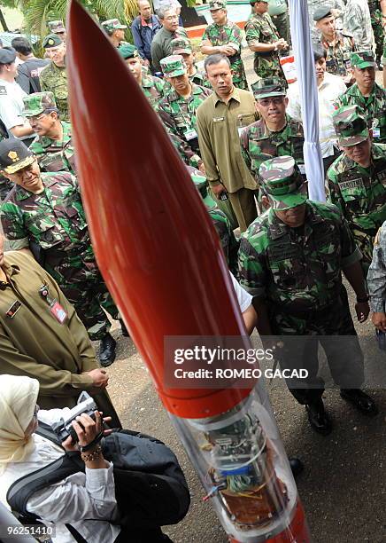 Photo taken on June 16, 2009 shows Indonesian military officials viewing a locally developed rocket during a military exhibition in Bandung. The...