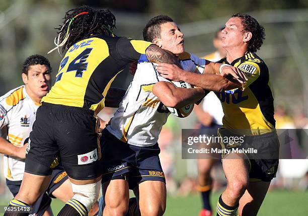 Matt Toomua of the Brumbies gets tackled by Ma'a Nonu and Willie Ripia of the Hurricanes during a Super 14 Trial match between the Hurricanes and the...