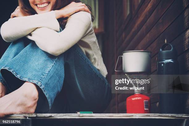 girl sitting next to boiling camping stove - metal decking stock pictures, royalty-free photos & images