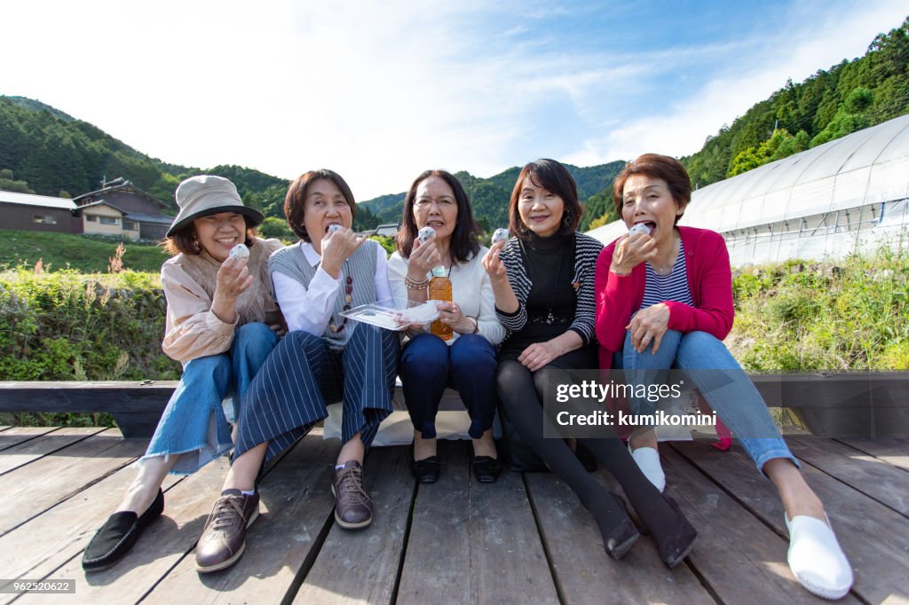 お菓子を食べて日本のシニアの女性のグループ