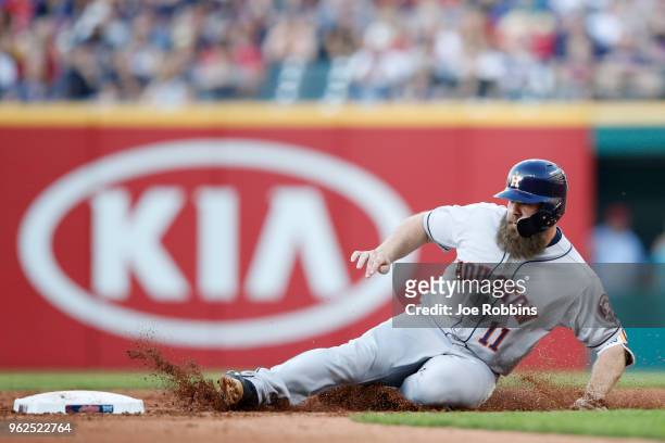 Evan Gattis of the Houston Astros slides at second base with a double in the third inning against the Cleveland Indians at Progressive Field on May...